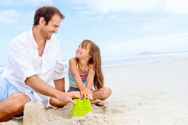 Padre e figlia costruzione castello di sabbia — Foto Stock