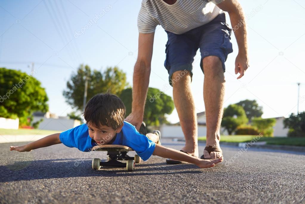 boy learning to ride skateboard