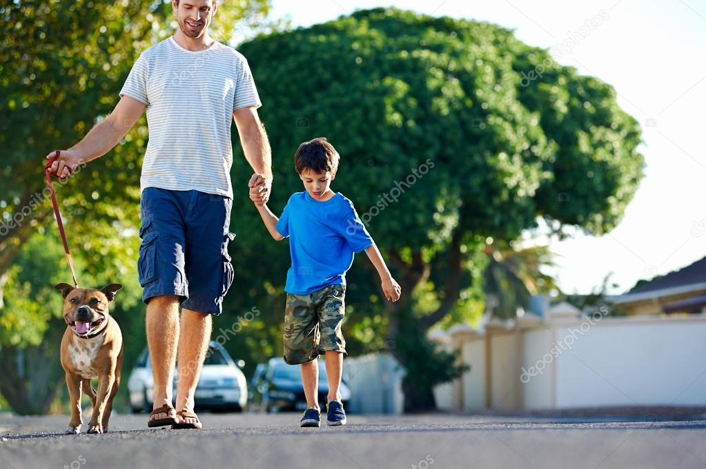 father walking with dog and son