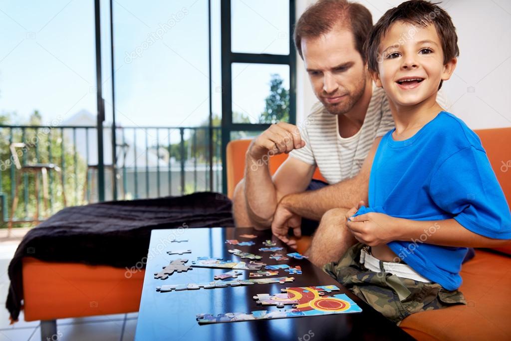 boy doing puzzle with father