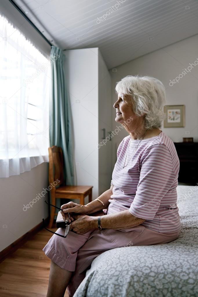 senior widow on bed feeling sad