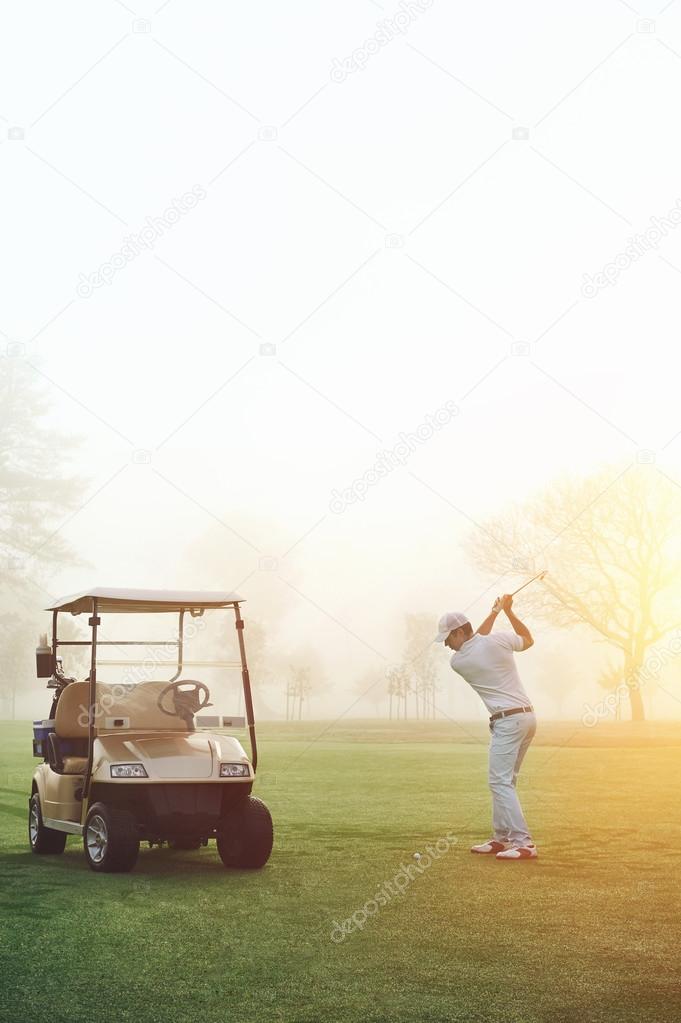 Golf man at sunrise playing