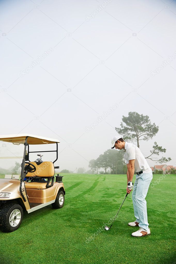 Golfer in fairway with cart