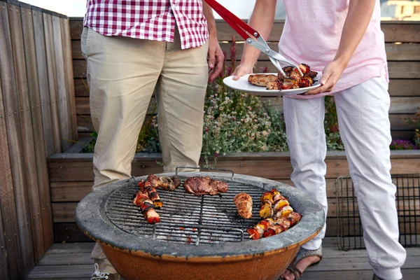 Femme aidant au barbecue extérieur — Photo