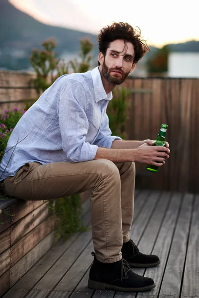 Νέος άνθρωπος που κρατά μπουκάλι μπύρας — Φωτογραφία Αρχείου