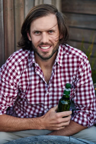 Jeune homme tenant une bouteille de bière — Photo