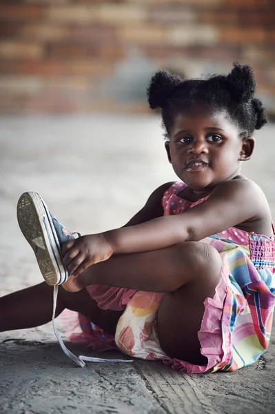 Африканская девушка завязывающая шнурки — стоковое фото