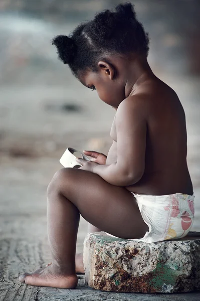 Bebê africano brincando com lixo — Fotografia de Stock