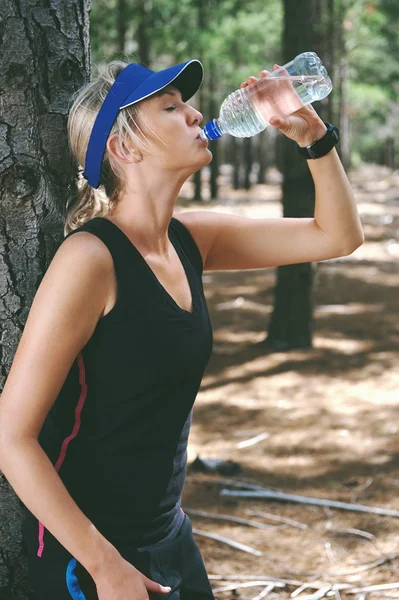 Runner resting and drinking water — Stock Photo, Image