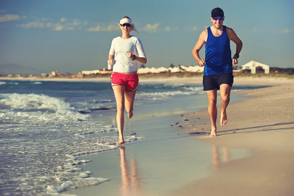 Пара біжить босоніж на пляжі — стокове фото