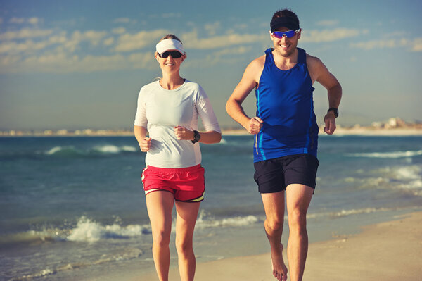 Couple running barefoot on beach