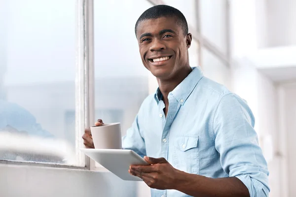 Afrikansk man med kaffe och tablett — Stockfoto