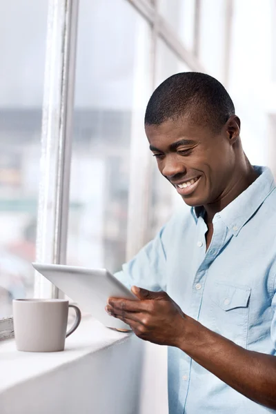 Afrikansk man med kaffe och tablett — Stockfoto