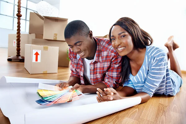 African couple deciding on colour swatch — Stock Photo, Image