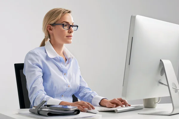 Mulher sentada na mesa trabalhando online — Fotografia de Stock