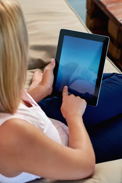 Frau auf Sofa liest E-Mail auf Tablet — Stockfoto