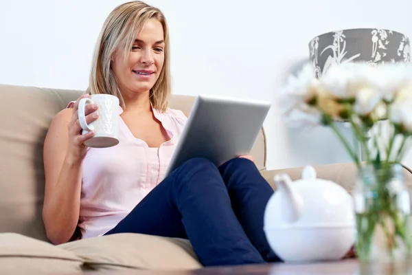 Mujer en sofá lectura de correo electrónico en la tableta — Foto de Stock