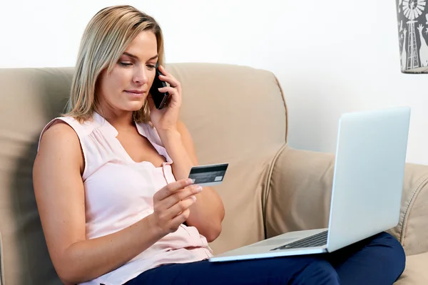 Женщина на диване покупки онлайн на дому — стоковое фото