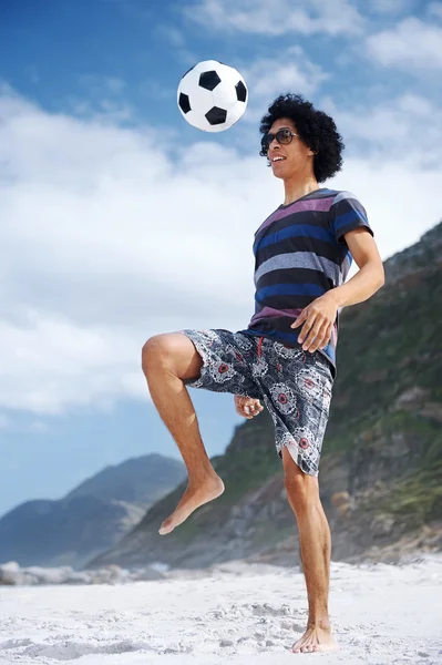 Homme avec ballon de football sur la plage — Photo