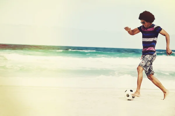 Brasilianischer Mann spielt Fußball am Strand — Stockfoto