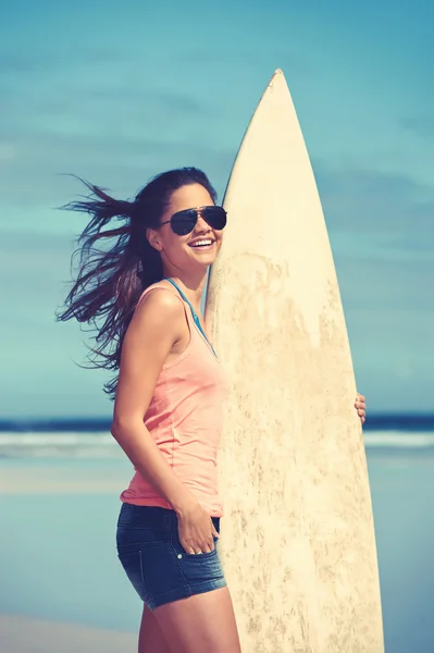 Young woman with surfboard at beach — Stock Photo, Image