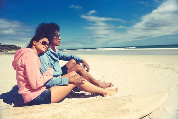 Couple latino assis sur la plage — Photo