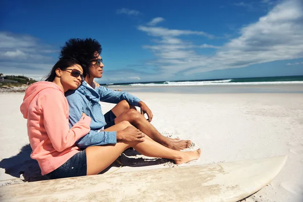 Latino pár ül a strandon — Stock Fotó