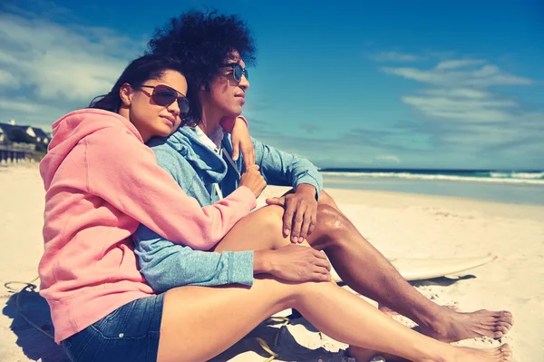 Latino casal sentado na praia — Fotografia de Stock