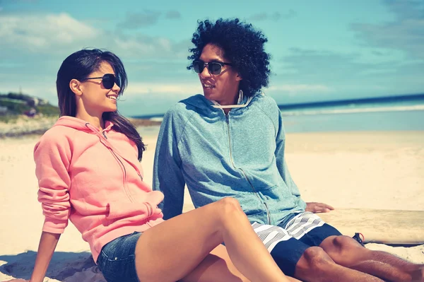 Coppia latina seduta sulla spiaggia — Foto Stock