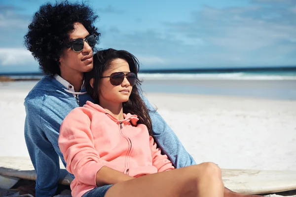 Coppia latina seduta sulla spiaggia — Foto Stock