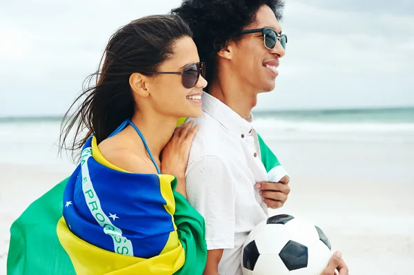 Пара с флагом Бразилии и мячом — стоковое фото