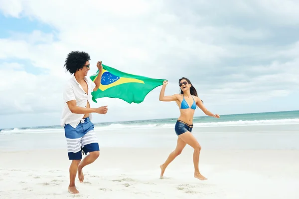 Hispanic couple holds Brasil flag — Stock Photo, Image