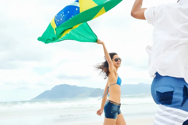 Hispanic couple holds Brasil flag — Stock Photo, Image