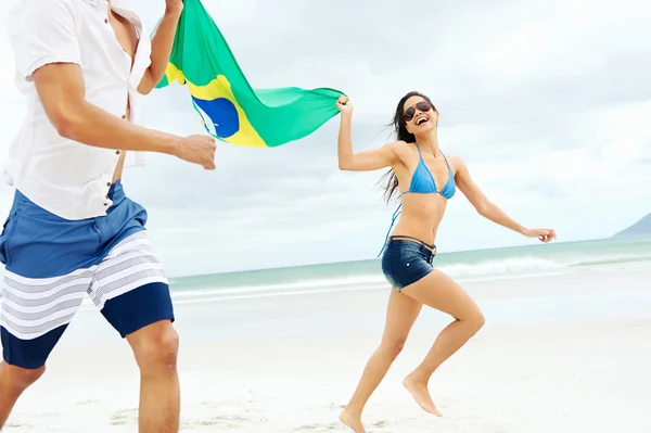 Coppia ispanica tenere bandiera brasiliana — Foto Stock