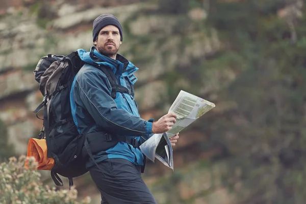 Uomo con mappa nelle montagne selvagge — Foto Stock