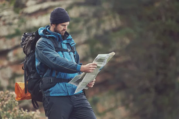 Homem com mapa explorando a natureza selvagem — Fotografia de Stock