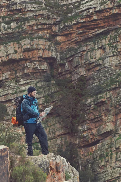 Man with map exploring wilderness — Stock Photo, Image