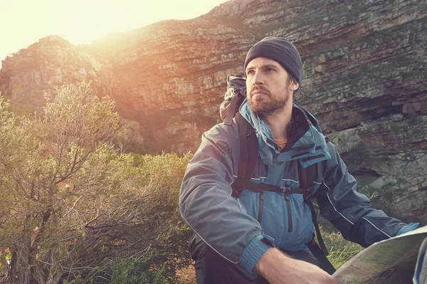 Man with map on mountain — Stock Photo, Image