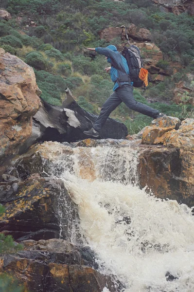 Hombre cruzando río en caminata extrema — Foto de Stock