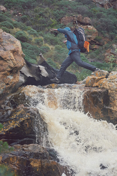 man crossing river on extreme hike