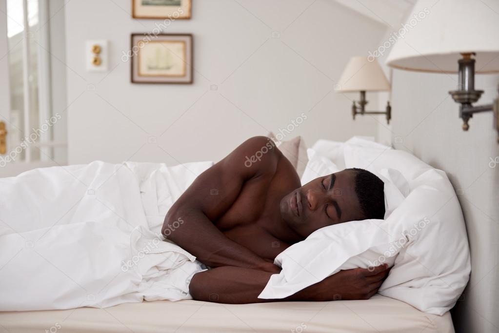 лежит под негром. женщины обнимаются с мужчинами узбекские. негр лежит на кровати. негр в кроватке. афроамериканец лежит.