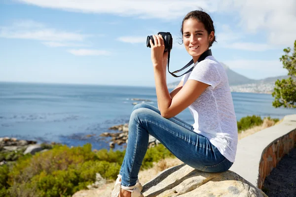 Porträtt av en ung attraktiv kvinna sitter på en sten med gräva — Stockfoto