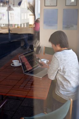 Asian woman on laptop, coffee break