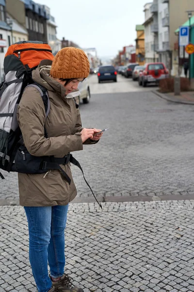 Mujer viajera en el teléfono celular en la acera de la ciudad — Foto de Stock