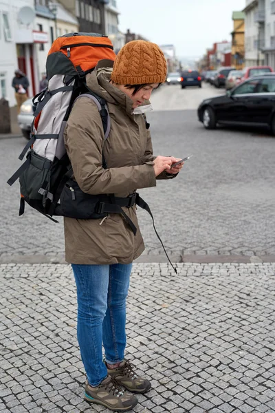 Mujer viajera en el teléfono celular en la acera de la ciudad — Foto de Stock
