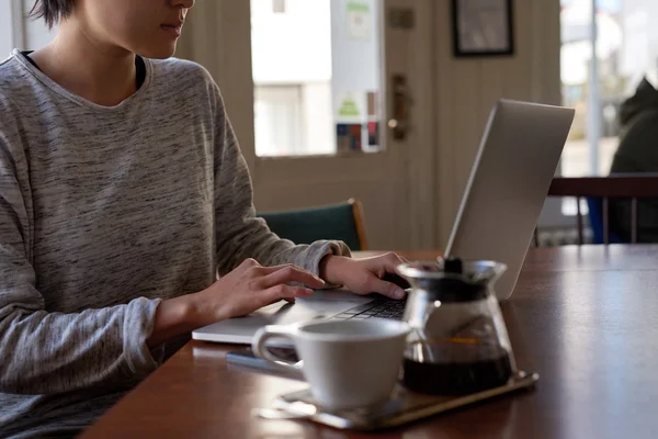 Woman on laptop, having coffee — Stockfoto