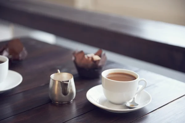Tasse und Untertasse mit Kaffee und Muffin — Stockfoto