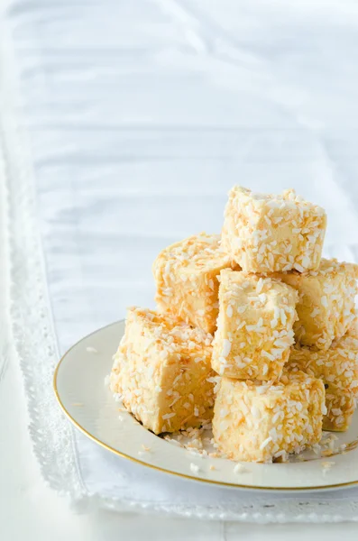 Golden marshmallow cubes with coconut bits — Stockfoto