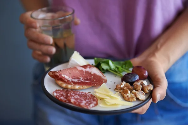 Mani che tengono piatto di spuntini — Foto Stock