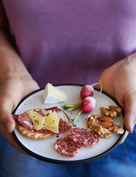 Mani che tengono piatto di spuntini — Foto Stock